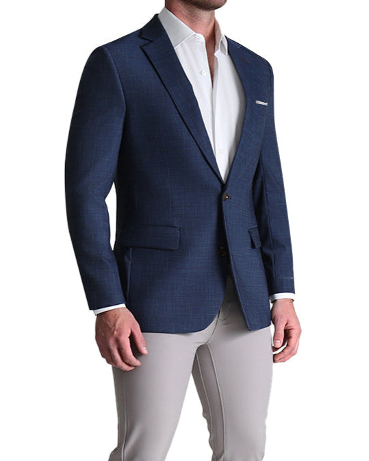 A male model wearing a heathered navy sport coat with a white shirt and beige pants.