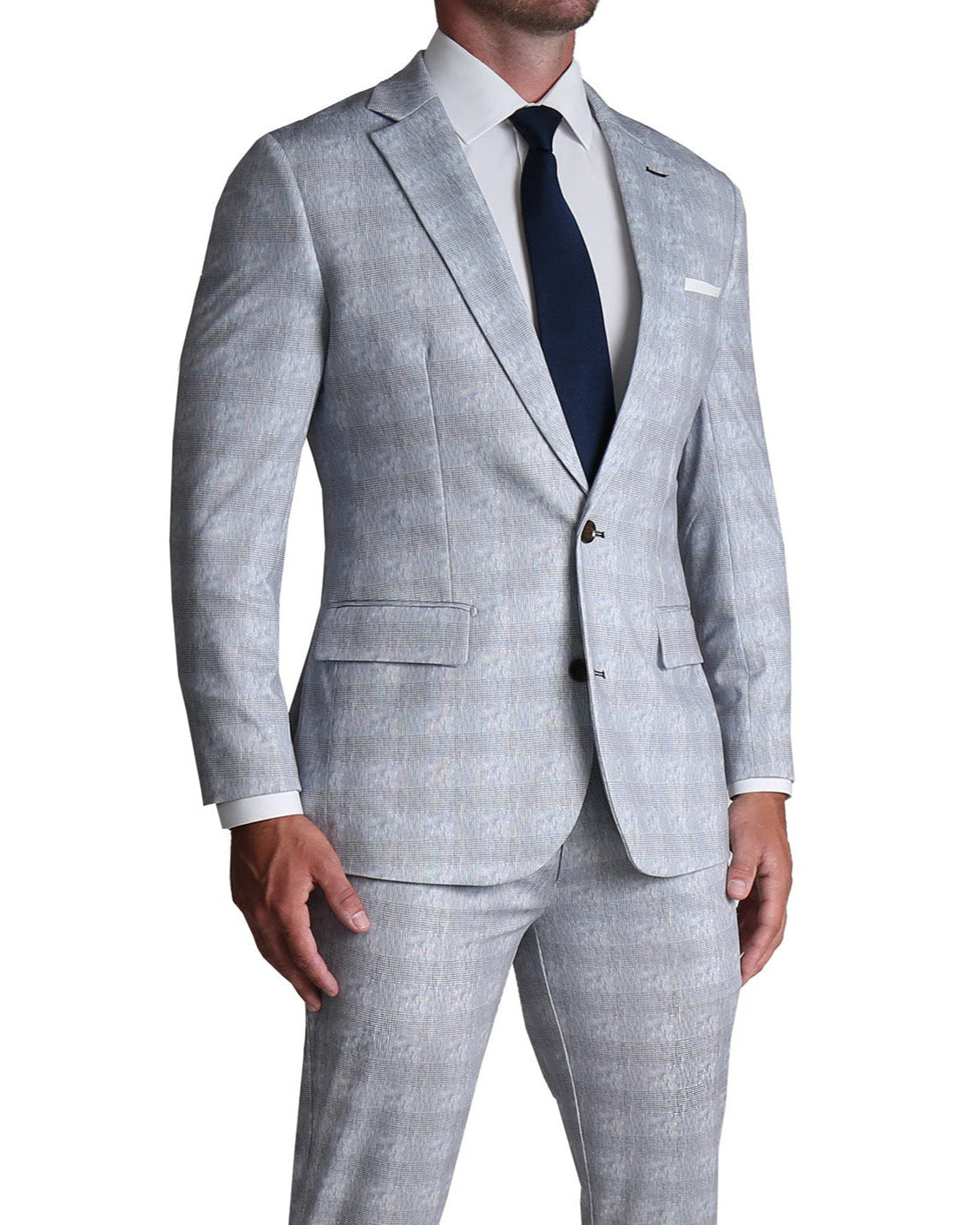 A man wearing a light grey plaid athletic fit stretch suit with a white shirt and a dark tie.