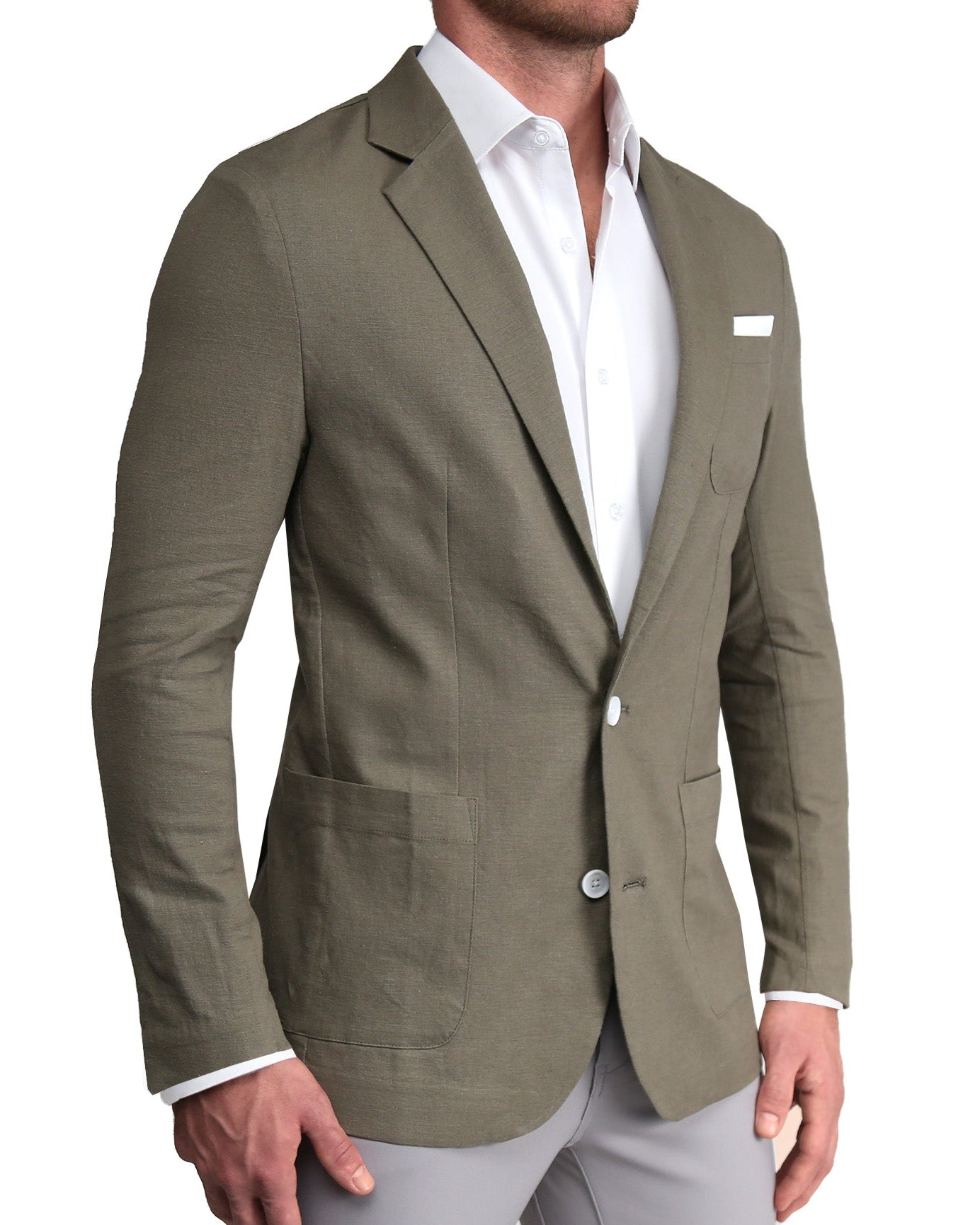 A male model wearing a dark olive unstructured linen blazer with a white dress shirt and light gray trousers. The blazer is buttoned, displaying the front and one of the pockets.