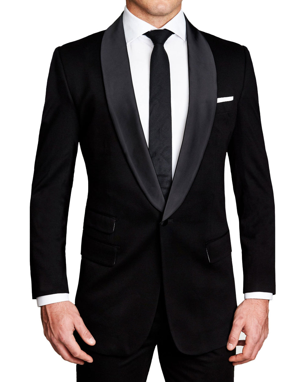 A man wearing a solid black athletic fit stretch tuxedo jacket with a shawl lapel, paired with a white dress shirt and a tie.