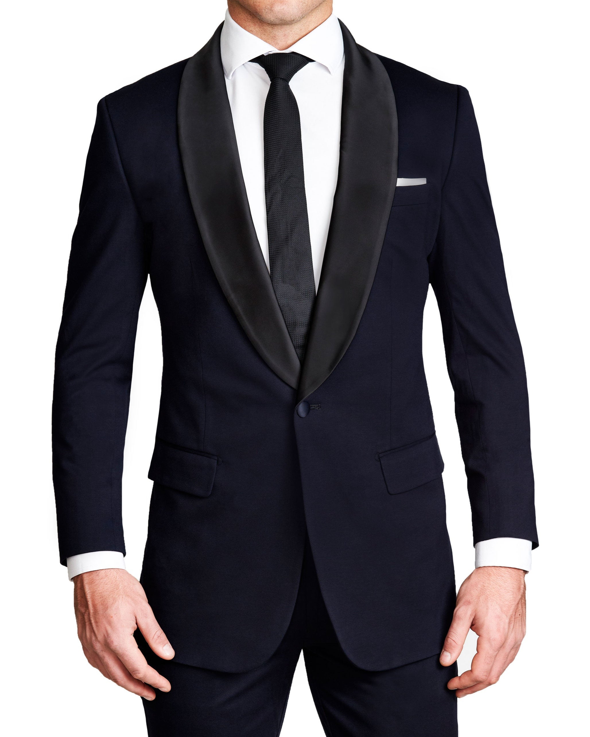 A man wearing a solid navy tuxedo with a shawl lapel, paired with a white dress shirt and a dark tie.