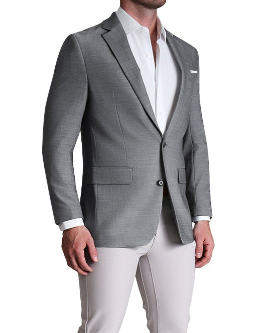A man wearing a heathered grey stretch blazer with a white shirt and light gray trousers.
