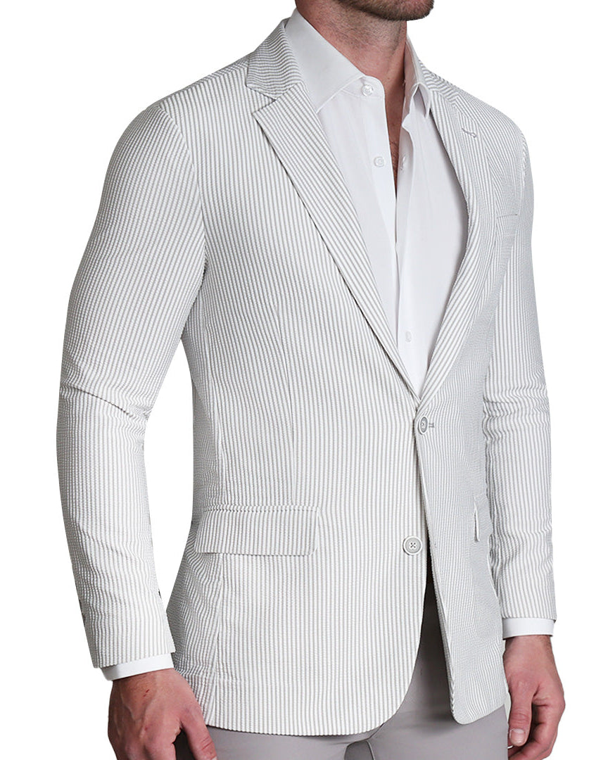A man wearing a grey seersucker two-button single-breasted blazer with medium notch lapels and flap pockets.
