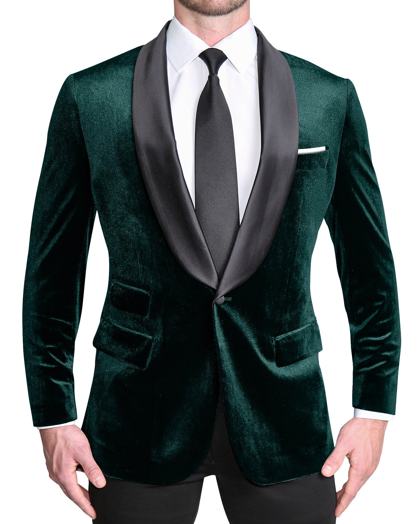A man wearing a green velvet tuxedo with a single button, shawl lapels, and black satin buttons. The tuxedo is tailored to fit an athletic build.