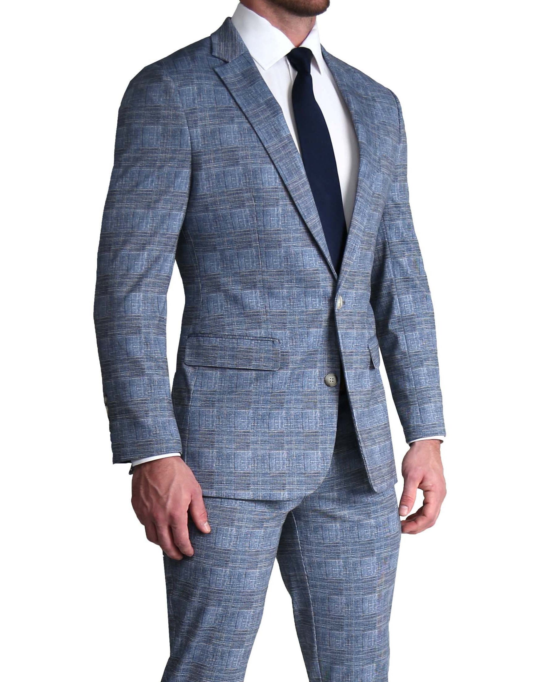 A man wearing a light blue, navy, and white plaid stretch suit with a single-breasted blazer and trousers, paired with a white shirt and a dark tie.