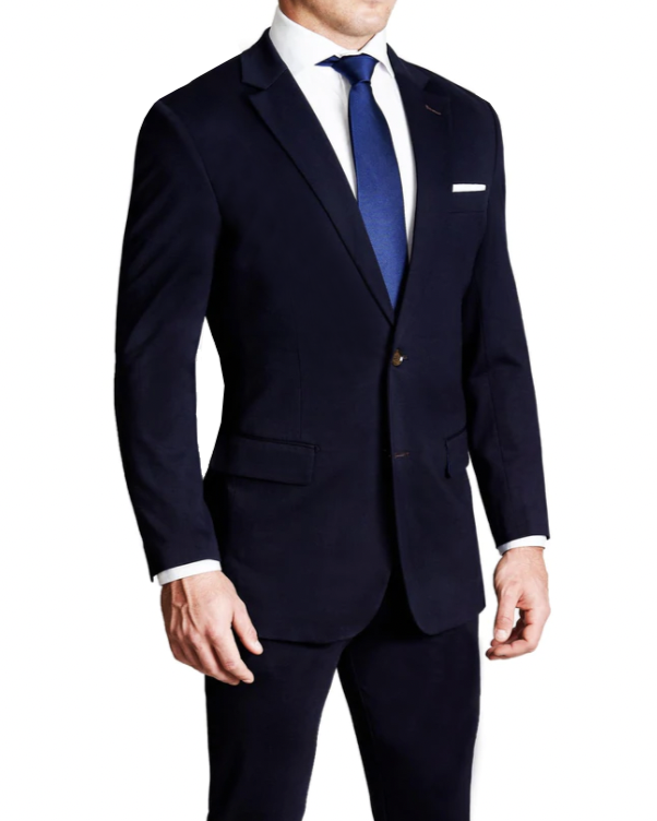 A man wearing a solid navy stretch suit with a white dress shirt and a blue tie.
