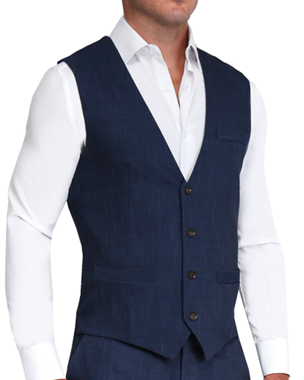 A man wearing a heathered navy stretch suit vest with a white shirt underneath. The vest has a single-breasted design with brown buttons and jetted pockets.