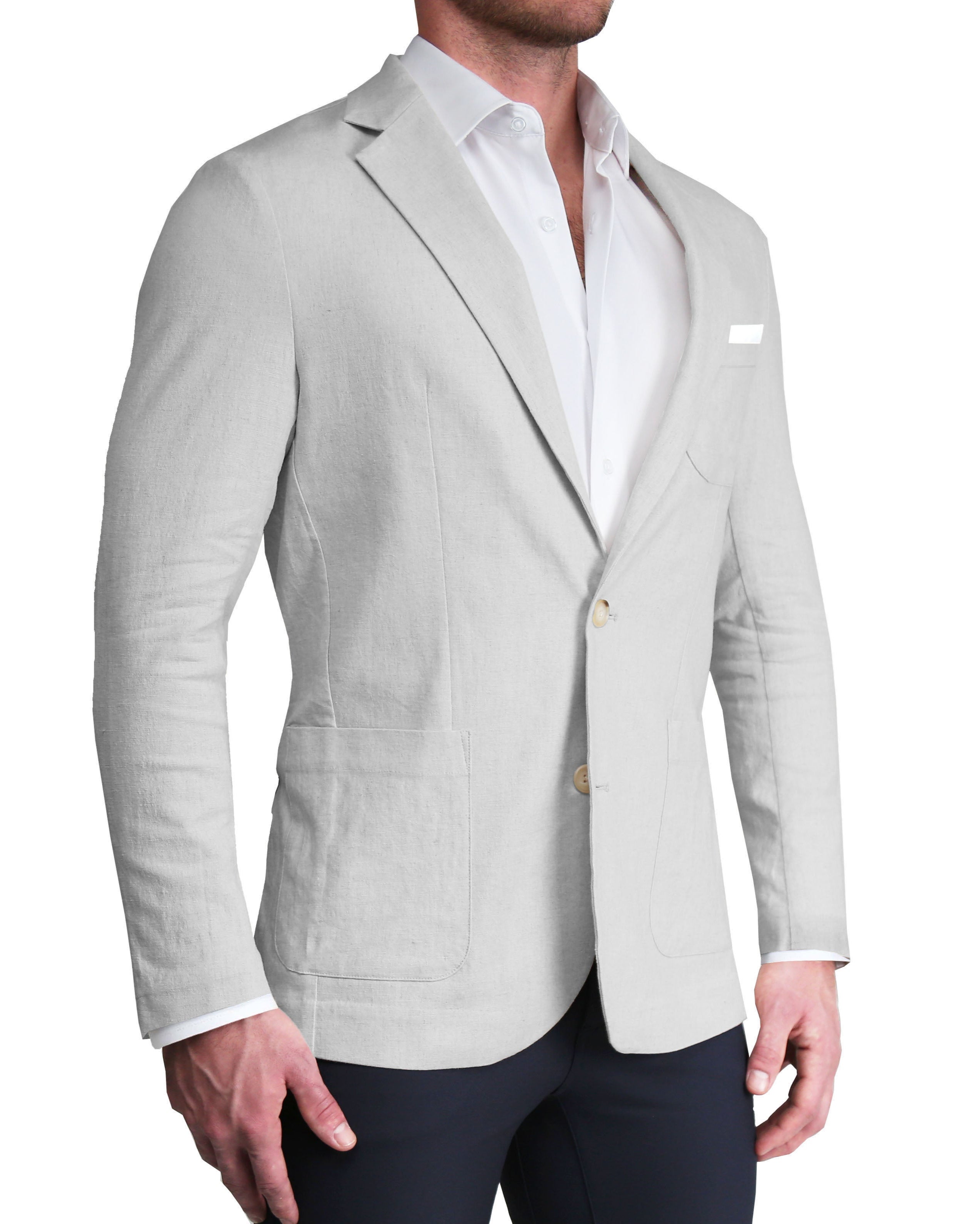 A man wearing a light grey unstructured linen blazer with a white shirt and dark trousers. The blazer features two-button single-breasted design, medium notch lapels, patch pockets, and functional buttons.